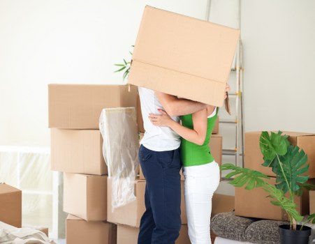 Moving team unloading boxes and furniture at a local home